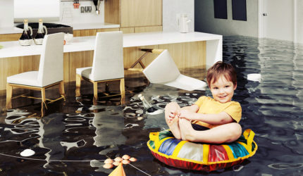 kid on flotation device in kitchen flooded with water